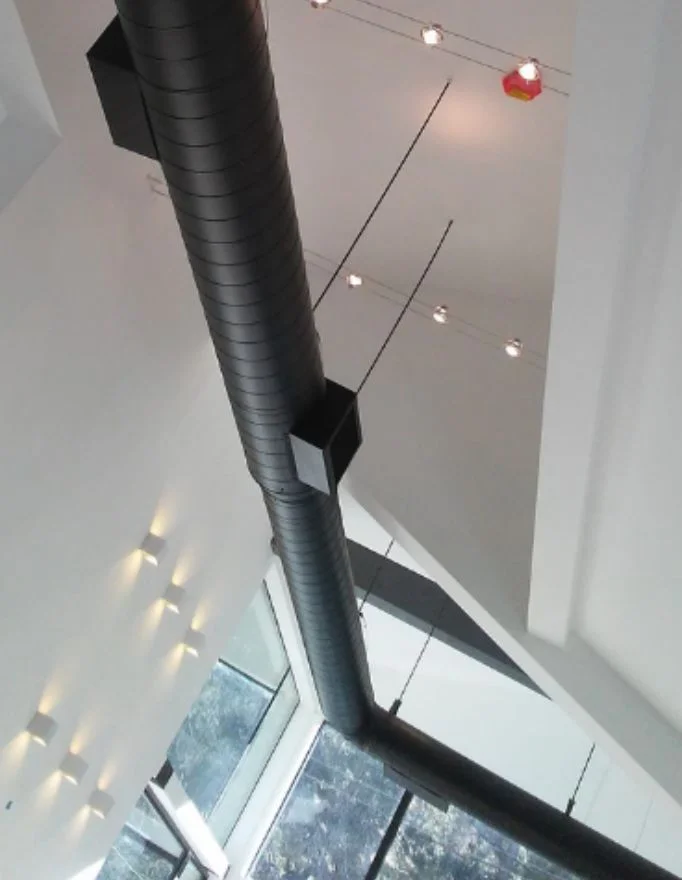 Finished commercial interior with exposed ductwork and architectural lighting